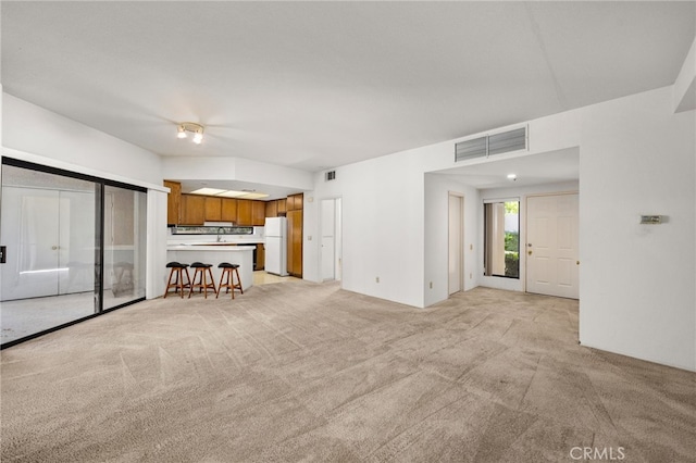 unfurnished living room featuring light colored carpet