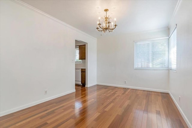 empty room with crown molding, hardwood / wood-style flooring, and a notable chandelier