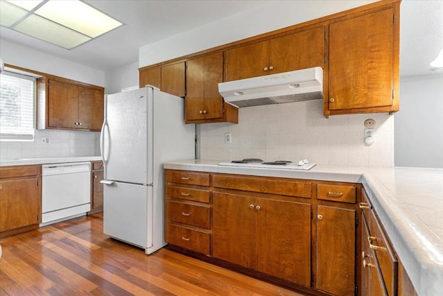 kitchen featuring tasteful backsplash, white appliances, and hardwood / wood-style floors