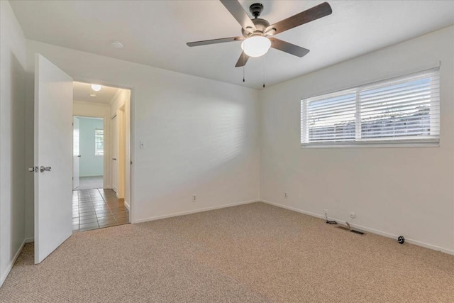 spare room featuring light carpet and ceiling fan