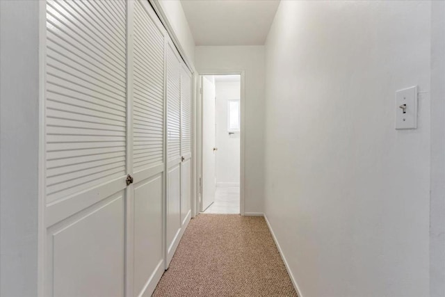 hallway featuring light colored carpet