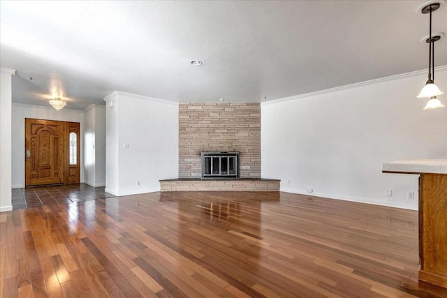 unfurnished living room with a fireplace, dark hardwood / wood-style flooring, and crown molding