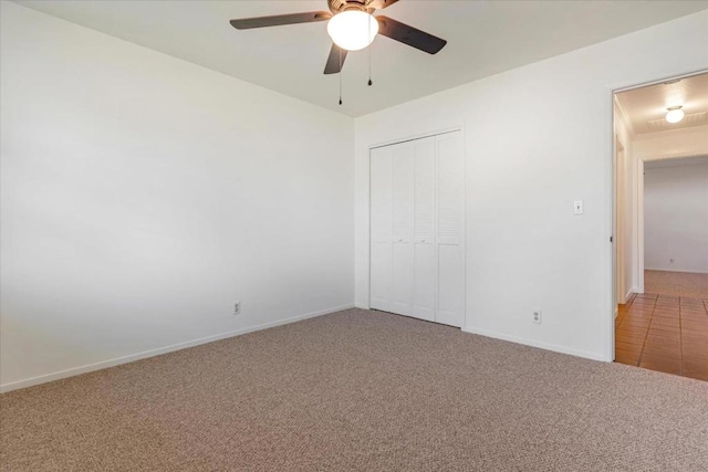 unfurnished bedroom with ceiling fan, carpet flooring, and a closet