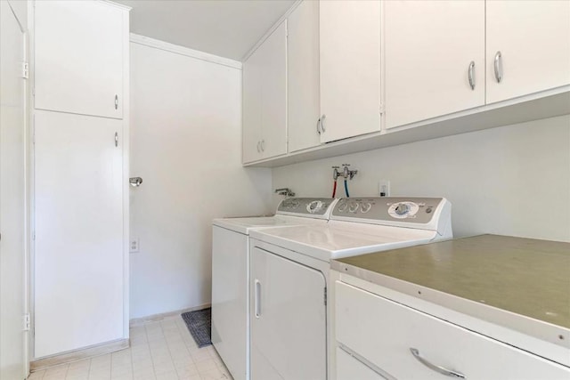 clothes washing area with cabinets and washer and dryer