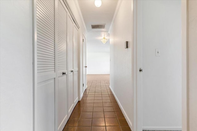 corridor with ornamental molding and dark tile patterned floors