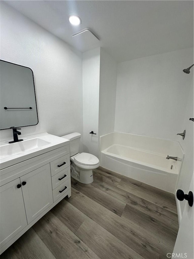 full bathroom featuring toilet, vanity, shower / bathing tub combination, and hardwood / wood-style floors