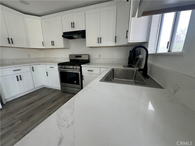 kitchen with white cabinetry, stainless steel gas range, dark hardwood / wood-style flooring, light stone counters, and sink