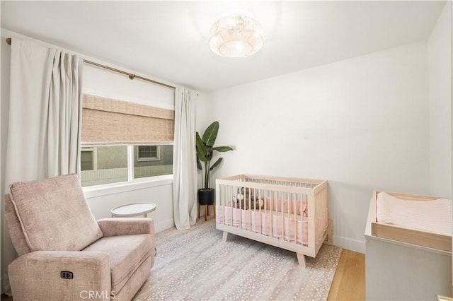 bedroom featuring light hardwood / wood-style floors and a crib