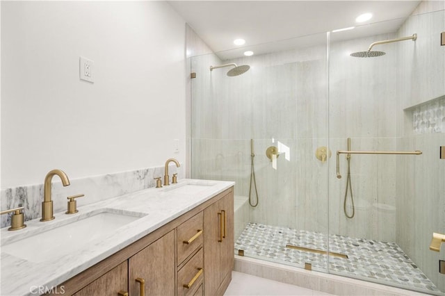 bathroom featuring a shower with shower door and vanity