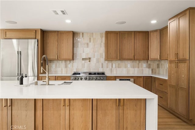 kitchen featuring sink, light wood-type flooring, stainless steel appliances, and tasteful backsplash