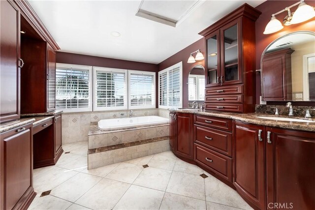 bathroom featuring a healthy amount of sunlight, tile patterned flooring, vanity, and tiled tub