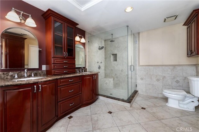 bathroom featuring toilet, tile walls, tile patterned floors, an enclosed shower, and vanity