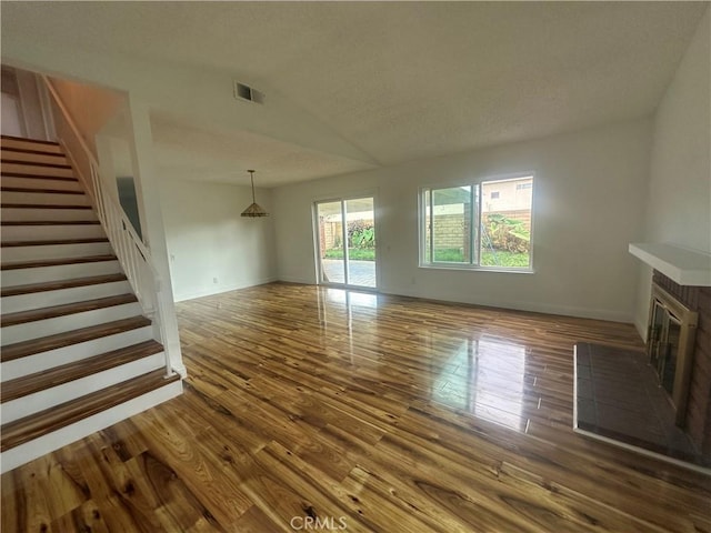 unfurnished living room featuring lofted ceiling and hardwood / wood-style flooring