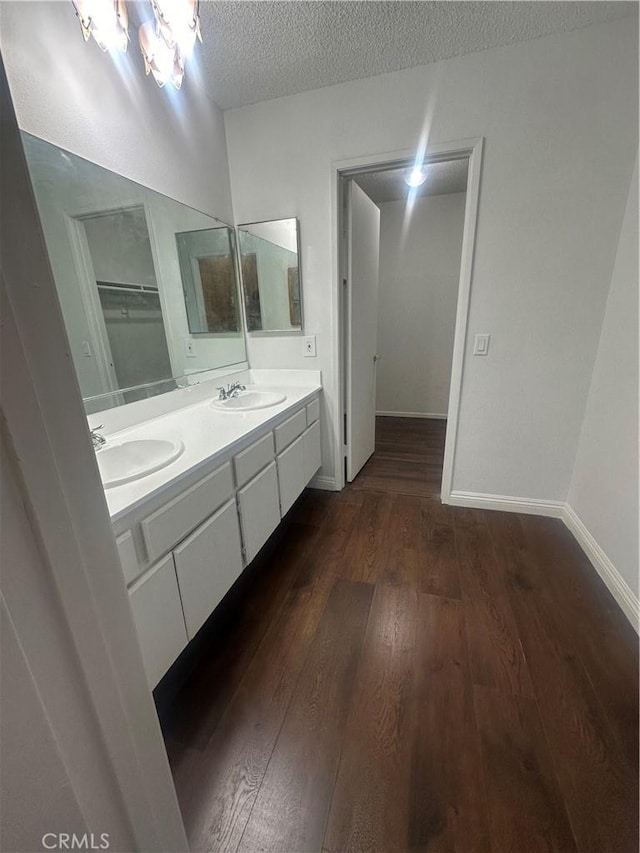 bathroom featuring hardwood / wood-style flooring, vanity, and a textured ceiling