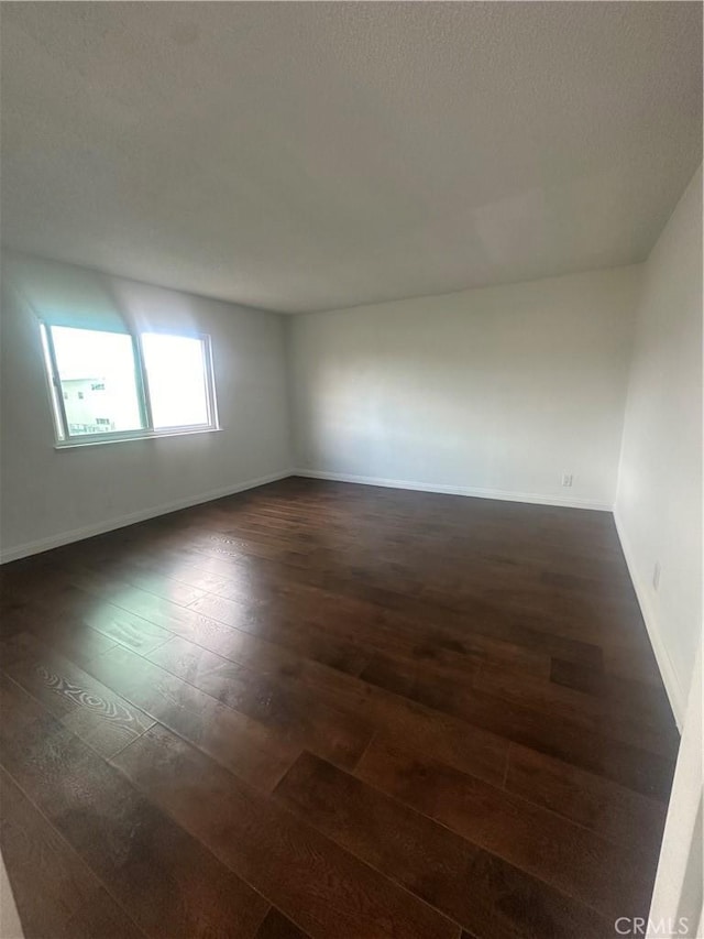 unfurnished room with dark wood-type flooring