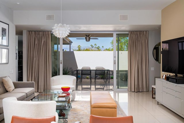 tiled living room with plenty of natural light and ceiling fan