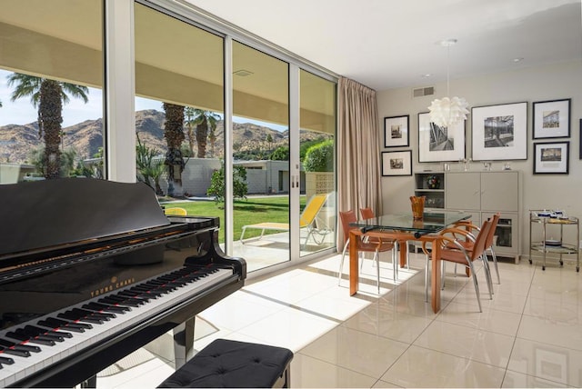 misc room featuring a mountain view, light tile patterned floors, and a wealth of natural light