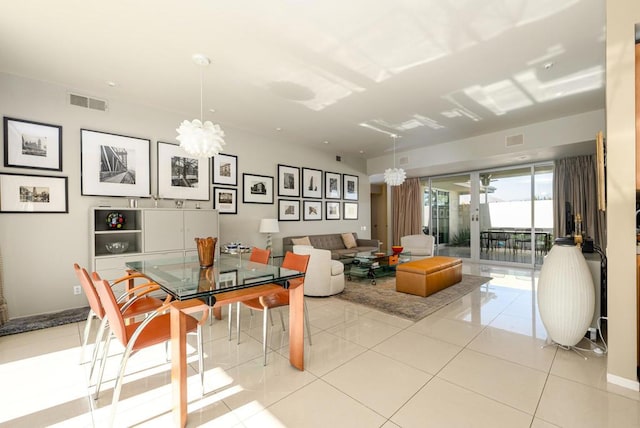 dining space featuring light tile patterned floors and an inviting chandelier