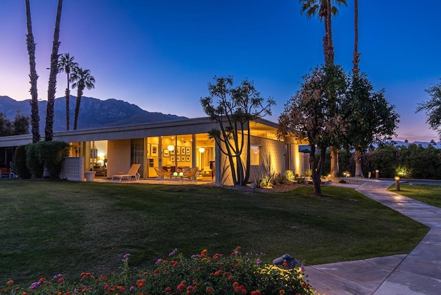 exterior space featuring a mountain view and a lawn