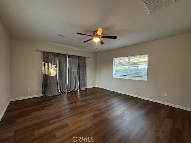 empty room with dark hardwood / wood-style flooring and ceiling fan