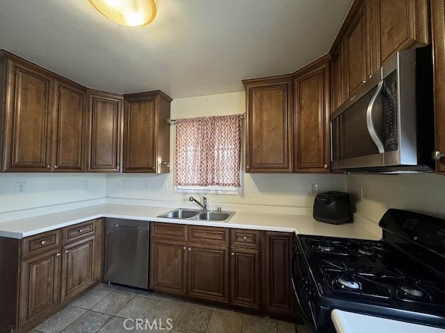 kitchen featuring dark brown cabinetry, sink, and appliances with stainless steel finishes