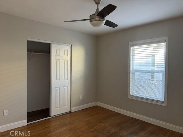 unfurnished bedroom featuring ceiling fan, a closet, and dark hardwood / wood-style floors