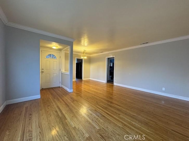 unfurnished living room featuring wood-type flooring and crown molding