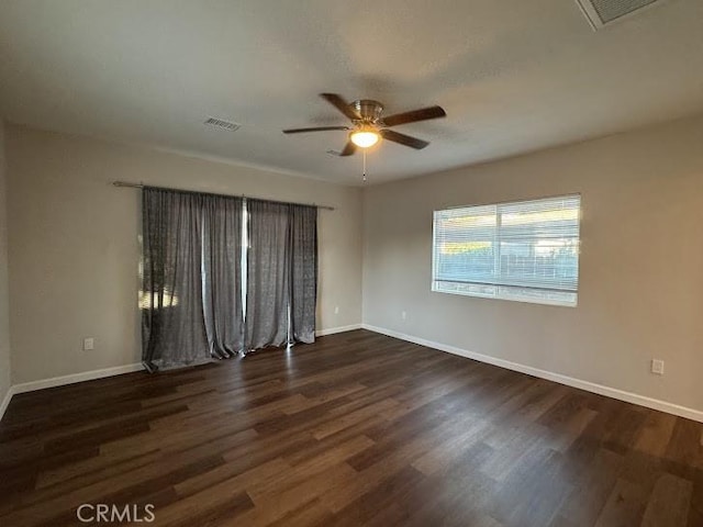 unfurnished room featuring ceiling fan and dark wood-type flooring