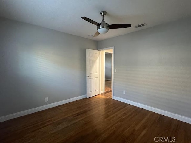 spare room with ceiling fan and dark hardwood / wood-style flooring