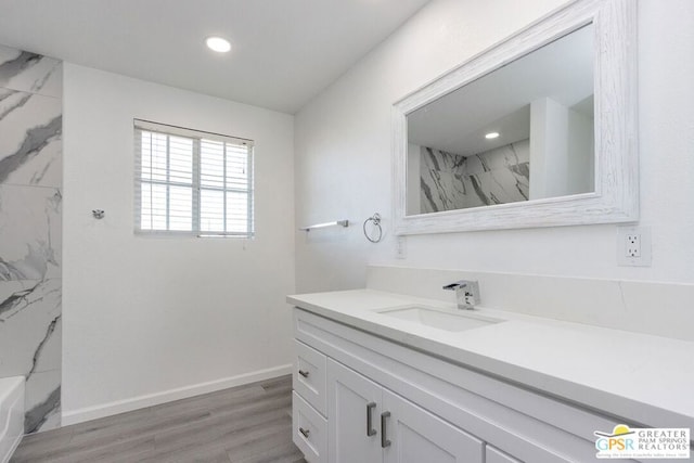 bathroom with a shower, hardwood / wood-style floors, and vanity