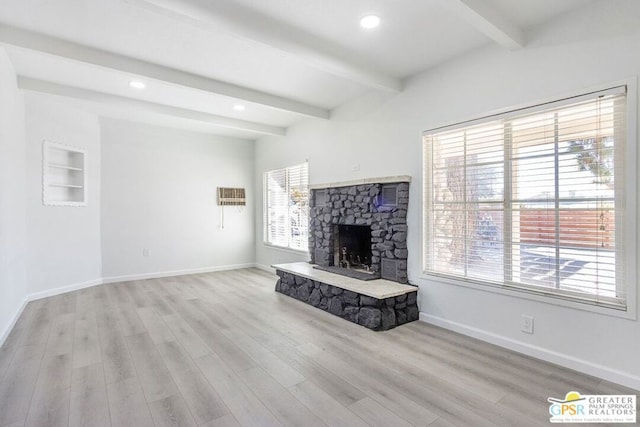 unfurnished living room featuring light hardwood / wood-style floors, built in shelves, beam ceiling, and a fireplace