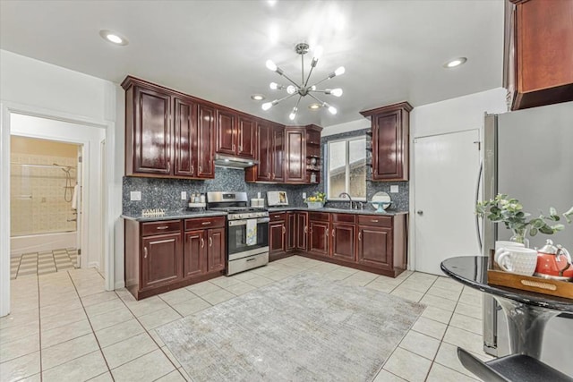 kitchen with gas stove, sink, light tile patterned flooring, and a chandelier