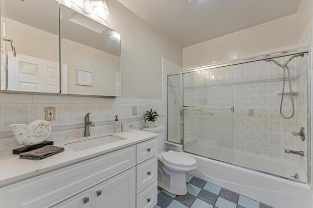 full bathroom with toilet, shower / bath combination with glass door, tile walls, vanity, and decorative backsplash