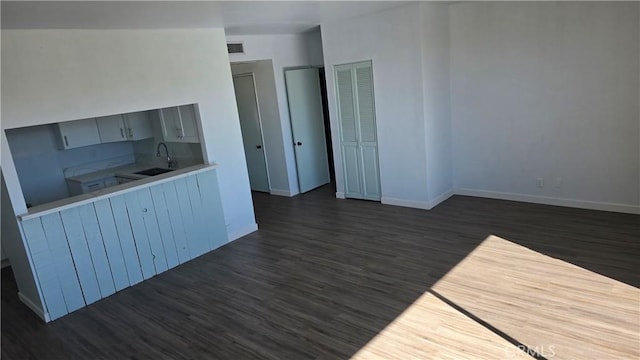 interior space with dark hardwood / wood-style floors, lofted ceiling, and sink