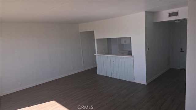 unfurnished living room with dark wood-type flooring