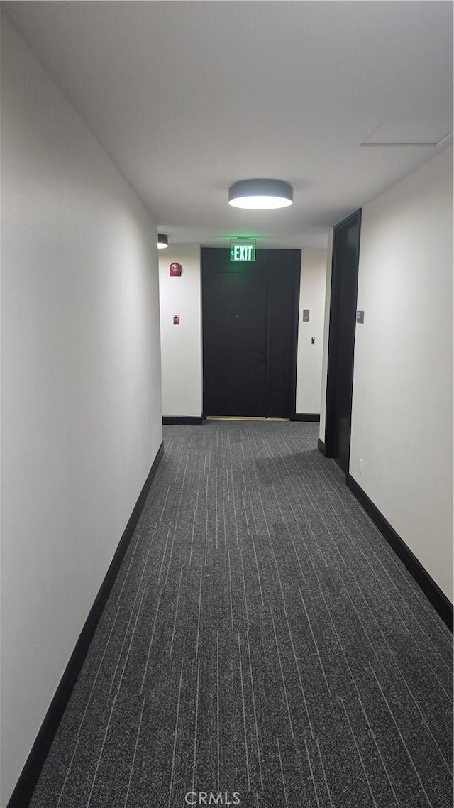 hall featuring dark colored carpet