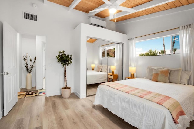 bedroom featuring ceiling fan, beamed ceiling, a wall mounted AC, wood ceiling, and light wood-type flooring