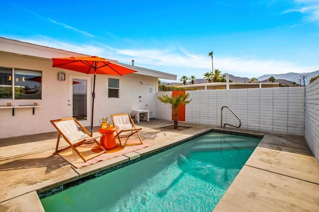 view of swimming pool featuring a mountain view and a patio