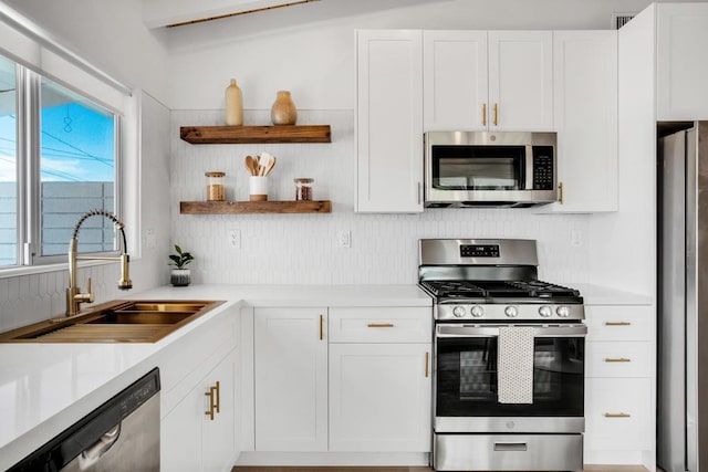 kitchen featuring white cabinetry, sink, and appliances with stainless steel finishes