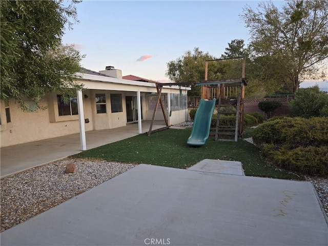 19345 Oneida Rd, Apple Valley, CA 92307 - yard at dusk featuring a playground and a patio