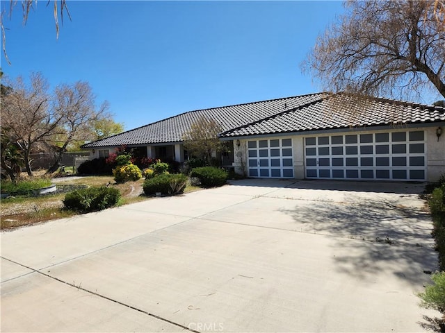 19345 Oneida Rd, Apple Valley, CA 92307 - view of front of home featuring an attached garage, concrete driveway, a tiled roof, and stucco siding