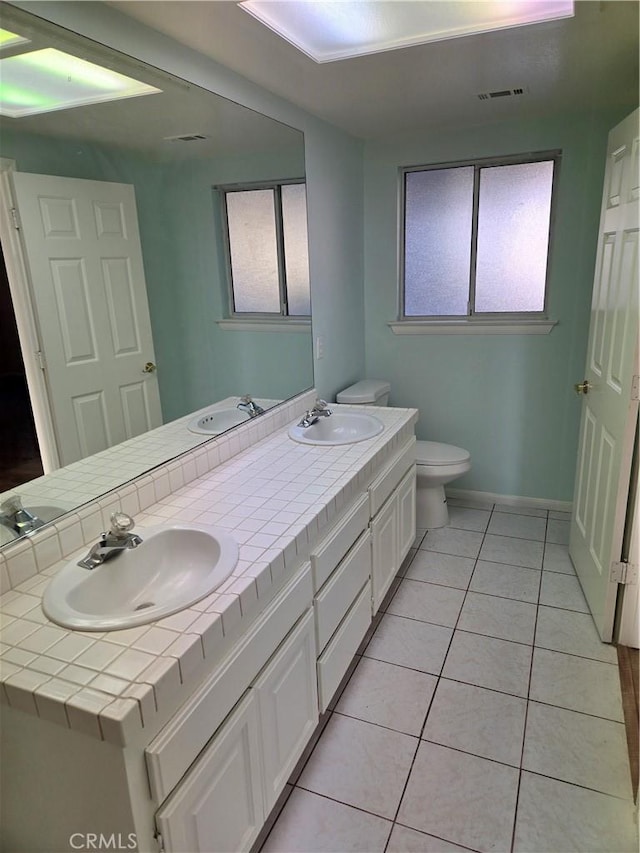 19345 Oneida Rd, Apple Valley, CA 92307 - full bath with double vanity, toilet, healthy amount of natural light, and tile patterned floors