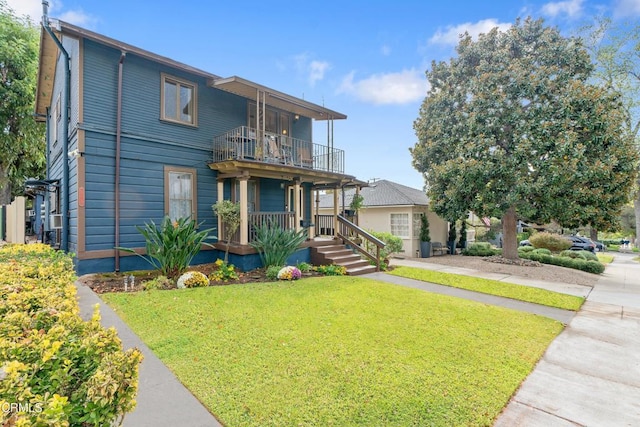 view of front of property with a porch, a balcony, and a front yard