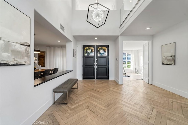 entrance foyer featuring a chandelier and light parquet floors