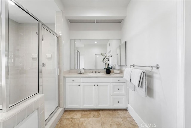 bathroom featuring tile patterned flooring, vanity, and walk in shower