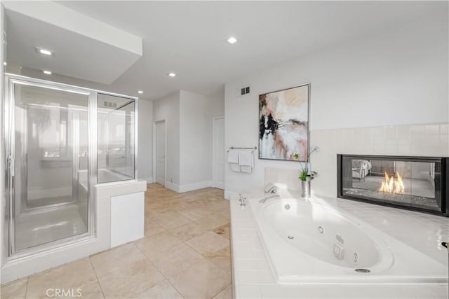 bathroom with a multi sided fireplace, separate shower and tub, and tile patterned floors