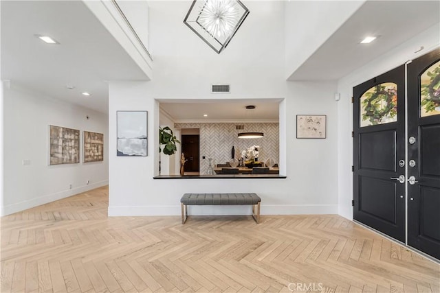 foyer entrance with crown molding and parquet floors