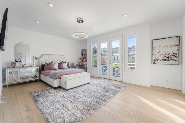 bedroom featuring wood-type flooring, access to outside, and french doors