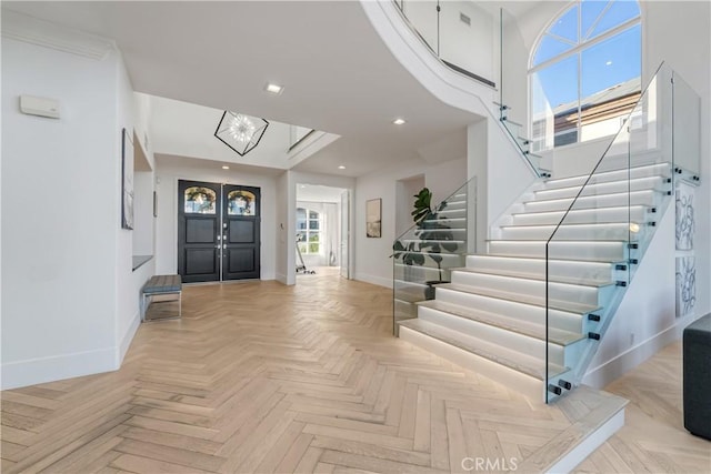 foyer featuring light parquet floors and an inviting chandelier