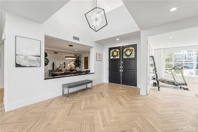 foyer entrance with light parquet flooring and an inviting chandelier